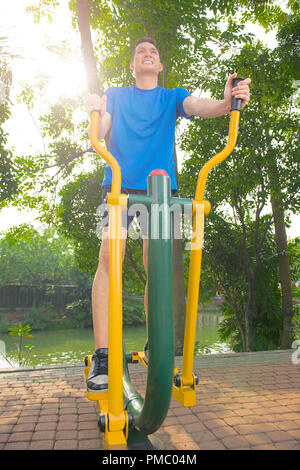 Portrait of asian man doing entraînement avec une machine elliptique at outdoor Banque D'Images