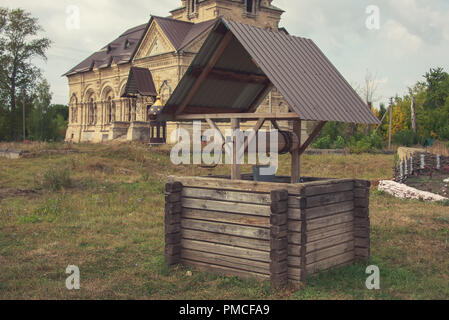 L'ancien puits pour l'eau avec une terrasse, d'un seau et d'une chaîne, Banque D'Images