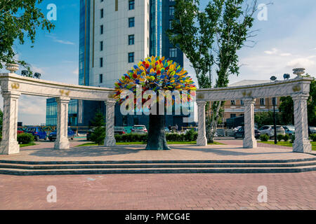 Arbre artificiel avec multi-feuilles colorées sur l'arrière-plan d'une arche de mariage avec cônes Banque D'Images