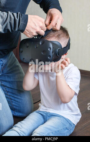 Le père porte son fils 4 ans vieux casque de réalité virtuelle, la technologie moderne, les enfants indigo Banque D'Images