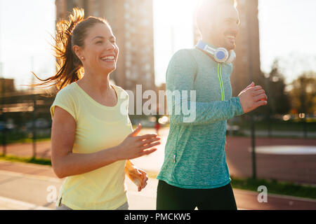Jeune beau couple fonctionne en dehors aux beaux jours Banque D'Images