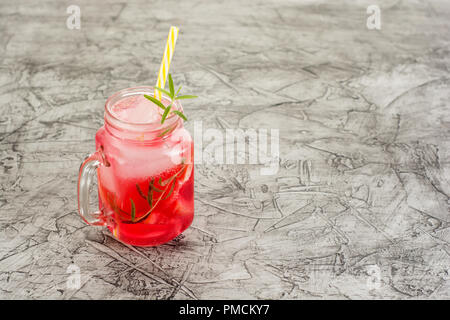 Limonade au pamplemousse. Verre de boisson detox, de l'eau avec des branches de romarin, pamplemousse et de glace. Concept de recette, cocktail. Banque D'Images