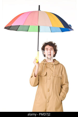 Homme portant un imperméable en pointant son parapluie Banque D'Images