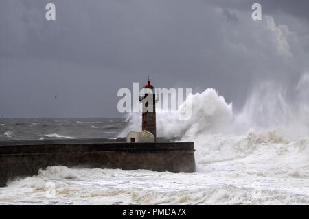 Big White vagues de Piers et phare contre une sombre tempête ciel nuageux. La bouche de la rivière Douro, Porto, Portugal. Banque D'Images