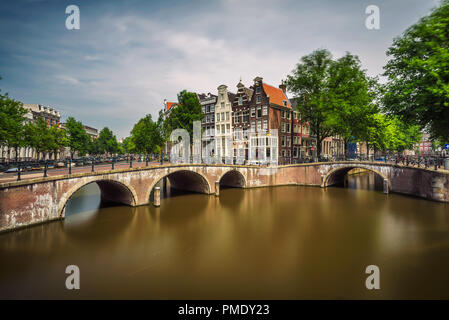 Célèbre canal Keizersgracht intersection avec pont historique et bâtiments à Amsterdam. Longue exposition. Banque D'Images
