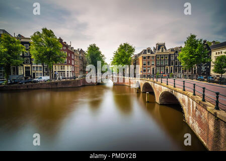 Célèbre canal Keizersgracht intersection avec pont historique et bâtiments à Amsterdam. Longue exposition. Banque D'Images