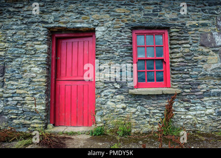 Un vintage porte et fenêtre sur une façade d'une vieille maison de pierres en Irlande Banque D'Images
