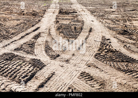 Des traces de pneus de voiture symétrique sur le terrain sale journée ensoleillée d'automne en Banque D'Images