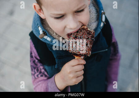 Jeune garçon de manger des gaufres pour le petit déjeuner. Gaufres Belges Banque D'Images