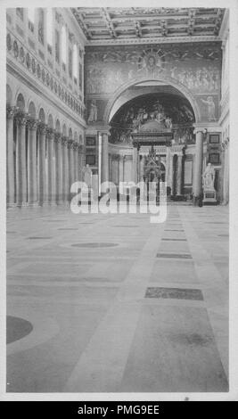 Photographie en noir et blanc sur papier cartonné, avec une image de l'intérieur d'une église catholique, tourné à partir d'un angle faible, regard vers l'abside et de l'autel, avec un petit autel gothique, avec les capitales, crocket près d'un tabernacle ouvragé, effectué sur quatre colonnes, avec mosaïques religieuses dans l'abside, d'un entablement, et supérieure de mur, un plafond à caissons, une colonnade de colonnes corinthiennes visible à gauche, et d'une marqueterie de marbre marbre, probablement perçus comme un souvenir touristique lors d'un voyage en Europe du Nord (probablement dans une région du Rhin Supérieur, près des frontières de l'Allemagne, la Suisse, et Fr Banque D'Images