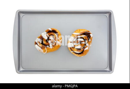 Vue de dessus du chaud, des petits pains à la cannelle sur une plaque isolé sur un fond blanc. Banque D'Images