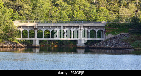 Vue éloignée sur un vieux pont en béton fissuré sur une rivière à marées sur la côte du Maine. Banque D'Images