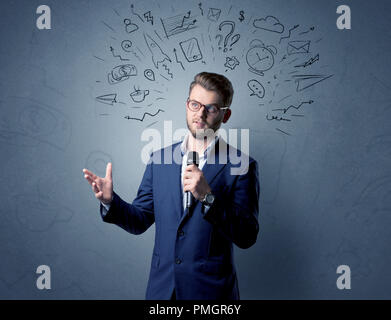Businessman parlant au micro avec des doodles sur sa tête Banque D'Images