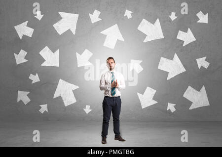 Handsome businessman debout devant un mur avec des flèches tirées de craie Banque D'Images
