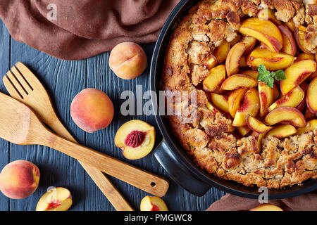 Délicieux et légèrement sweet peach cobbler dans un plat de cuisson noir, vue de dessus, télévision lay Banque D'Images