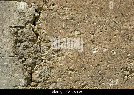 Une grande fissure dans le mur d'un bâtiment rustique en menace la stabilité. Banque D'Images