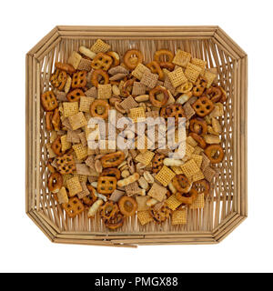 Vue de dessus d'un petit panier en osier rempli de cacahuètes et un assortiment de bretzels croustillants craquelins gaufres et isolé sur un fond blanc. Banque D'Images