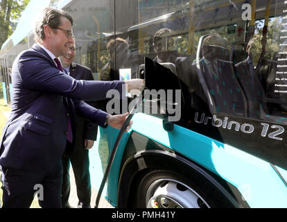 18 septembre 2018, Berlin : Andreas Scheuer (CSU), Ministre fédéral des Transports, de "fossiles" un bus électrique au Salon ferroviaire INNOTRANS, sur le parc des expositions entre les halls de la tour radio. Photo : Wolfgang Kumm/dpa Banque D'Images