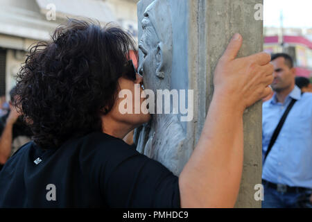 Le Pirée, Grèce. 18 Sep, 2018. Pavlos Fyssas' mère Magda Fyssa embrasse fils's Memorial dans le port du Pirée faubourg de Keratsini, Grèce, le 18 septembre 2018. Les groupes anti-fasciste a organisé une série de manifestations à Athènes et dans d'autres villes de Grèce mardi, cinq ans après l'assassinat de 34 ans musicien Pavlos Fyssas par un parti d'extrême droite. Credit : Marios Lolos/Xinhua/Alamy Live News Banque D'Images