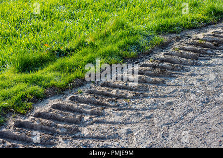 Les traces de pneus du tracteur montrant des dommages à la bordure de la route de pays - la France. Banque D'Images