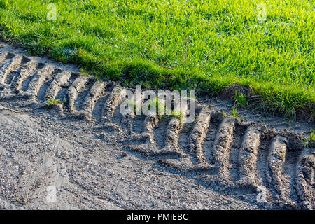 Les traces de pneus du tracteur montrant des dommages à la bordure de la route de pays - la France. Banque D'Images