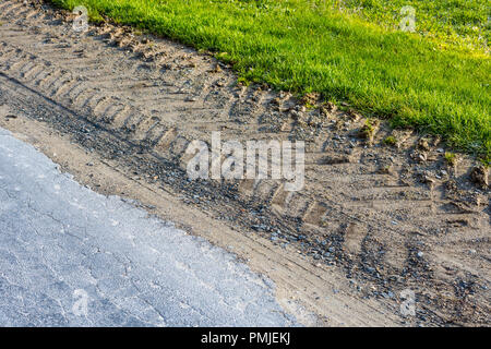 Les traces de pneus du tracteur montrant des dommages à la bordure de la route de pays - la France. Banque D'Images