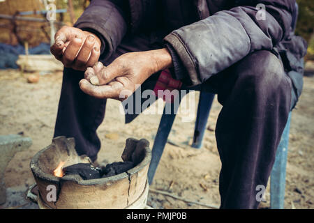 Portrait vieil homme sur les régions rurales de la Thaïlande dans la saison d'hiver avec la petite cheminée - gain filtre bruit appliqué Banque D'Images