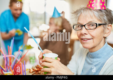 Senior woman in maison de retraite fête anniversaire avec des amis et de la famille Banque D'Images