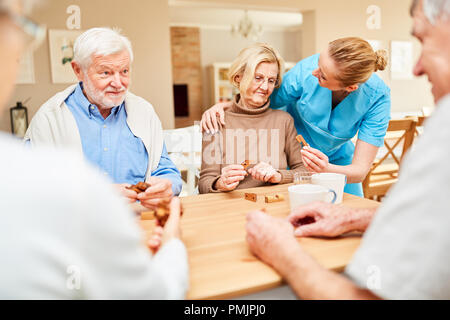 Soignant s'occupe d'une femme senior de démence en jouant avec le puzzle en bois Banque D'Images