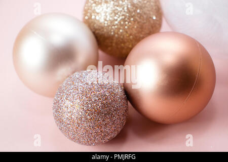 Boules de Noël en or rose sur fond rose Banque D'Images