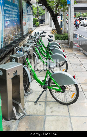 Rangée d'un service de location de vélos publics verts dans les stations d'accueil sur la rue à Bangkok, Thaïlande Banque D'Images