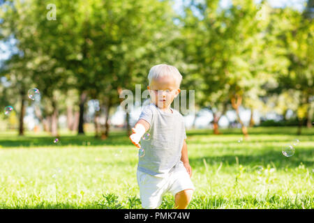 Petite nice enfant attraper des bulles de savon à l'extérieur Banque D'Images