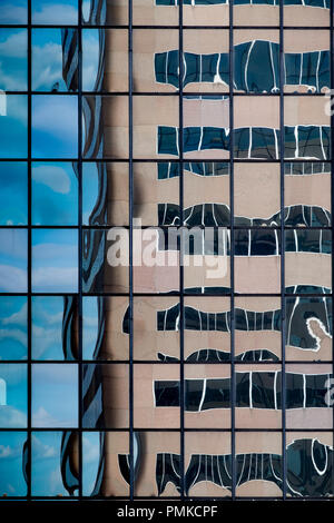 Détail de l'architecture en immeuble de bureaux, à Birmingham en Alabama. Un reflet déformé d'un immeuble de bureaux dans le reflet d'un autre bloc de bureau Windows. Banque D'Images