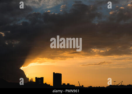 Coucher du soleil spectaculaire sur une ville moderne avec des blocs de haute tour qui se profile à l'horizon Banque D'Images