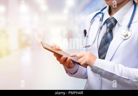 Femme médecin holding tablet et pointant l'index sur l'écran à l'hôpital ou l'arrière-plan flou de PPO Banque D'Images