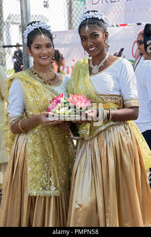 Portrait de posé 2 belles jeunes femmes tenant des fleurs au Défilé 2018 Madrassi à Richmond Hill, Queens, New York. Banque D'Images