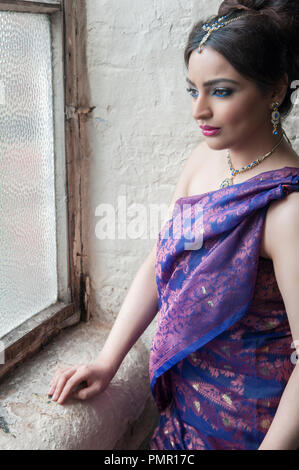 Beautiful Indian woman looking out of window Banque D'Images