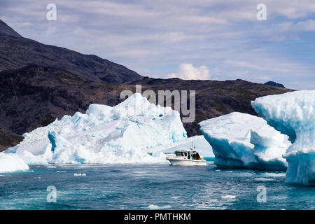 Les petits bateaux de navigation dans le fjord Tunulliarfik près des grands icebergs d'icefjord Qooroq en été. Narsarsuaq, Kujalleq, le sud du Groenland. Banque D'Images