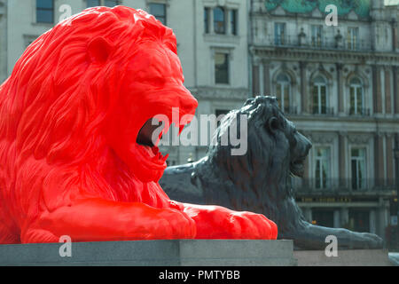 Londres, Royaume-Uni. 19 septembre 2018. 'Veuillez Nourrir les Lions', une oeuvre par artiste Es Devlin, a été installé à Trafalgar Square dans le cadre du London Design Festival. Le lion rouge fluorescent rejoint les quatre lions emblématique autour de la base de la Colonne Nelson. Les visiteurs sont invités à alimenter la nouvelle lion mots via une interface numérique qui le lion rugit sous la forme d'une ligne de la poésie du xixe siècle grâce à une LED dans sa bouche par jour, ou comme une projection sur la Colonne Nelson par nuit. Crédit : Stephen Chung/Alamy Live News Banque D'Images