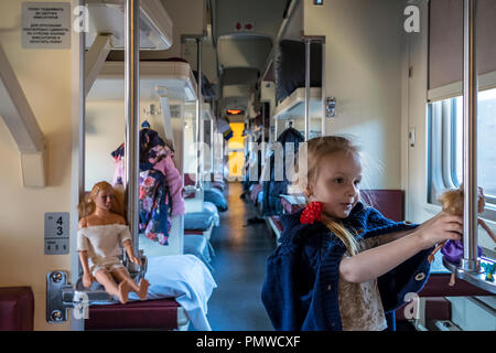 La petite fille russe joue avec les jouets dans le trans siberian express autour d'Omsk, en Russie. Banque D'Images