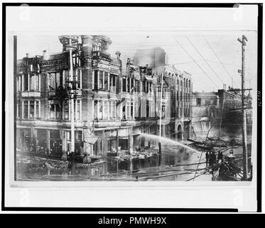 Bloc de bâtiments brûlés à San Francisco après le tremblement de terre de 1906 avec un camion à incendie pulvériser de l'eau sur eux Banque D'Images