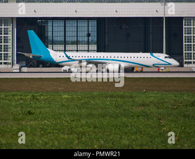 Un avion devant le hangar de la voie de circulation et d'un pré en premier plan Banque D'Images