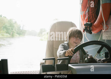 Souriant, playful girl sitting on circonscription tondeuse Banque D'Images