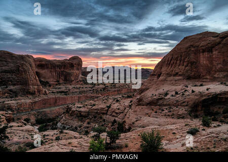 La vue au coucher du soleil dans le canyon vers le fleuve Colorado à partir de Corona Arch, Moab, Utah, USA Banque D'Images
