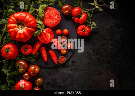 Tranches rouges frais et tomates sur fond noir, de l'espace pour votre texte Banque D'Images