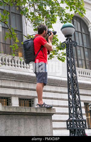 Un touriste dans la 42e rue à Manhattan debout à la lisière de rebord qui fait partie de l'extérieur de la succursale principale de la Bibliothèque publique de New York. Banque D'Images