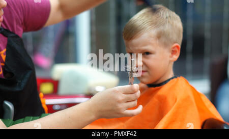 Coupe d'un petit garçon dans un salon de coiffure pour enfants Banque D'Images