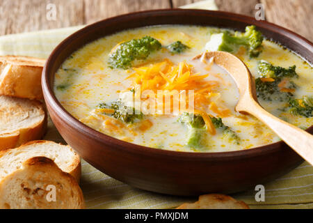 Le brocoli cuits dans un bol de soupe de fromage avec du pain grillé sur la table horizontale. Banque D'Images