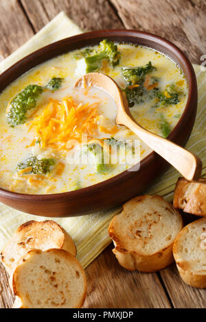 Soupe au fromage brocoli légumes chaud dans un bol avec du pain grillé libre sur une table verticale. Banque D'Images