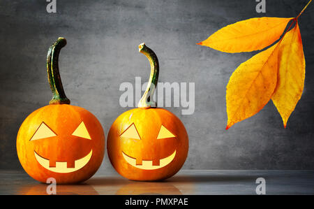 Lanterne citrouille Halloween avec des feuilles sèches avec fond noir. Banque D'Images